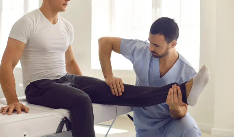 Knee Decompression Therapy Physical therapist in Wayne NJ guiding a patient through step-up rehab exercises in a modern clinic